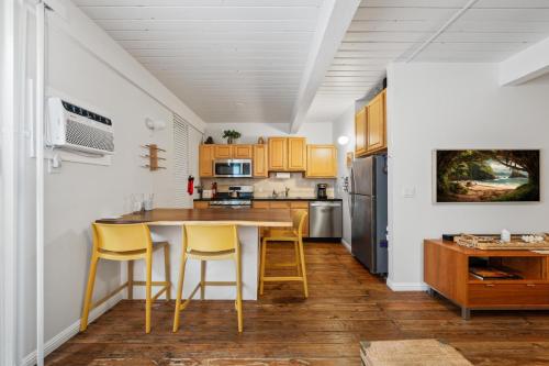 a kitchen with a wooden table and yellow chairs at Big Island Kona Mansions 110C by Coldwell Banker Island Vacations in Kailua-Kona