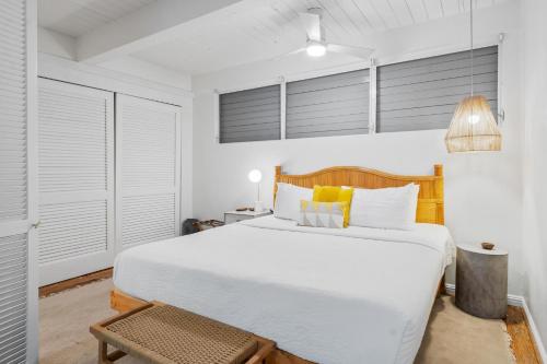 a white bedroom with a large bed and a table at Big Island Kona Mansions 110C by Coldwell Banker Island Vacations in Kailua-Kona