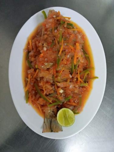 a plate of food with a bowl of soup with a lime at Kareem Zanzibar in Zanzibar City