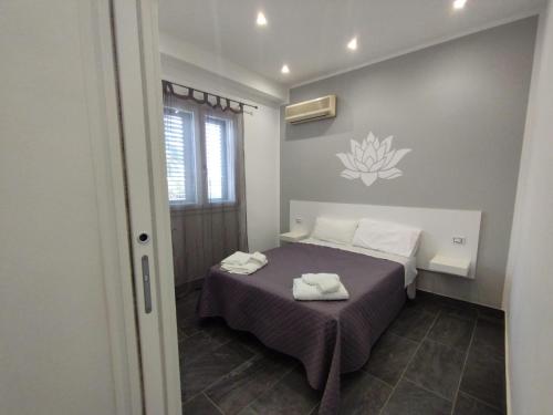 a bedroom with a bed with two towels on it at Fiore di Loto Rooms in Carini