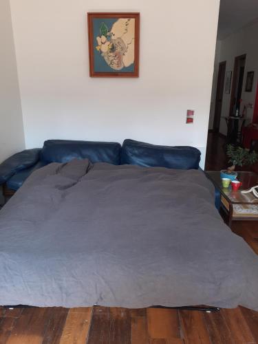 - un lit avec une couverture bleue dans l'établissement superbe 2 pièces au centre de paris, à Paris