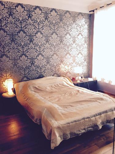 - une chambre avec un lit, deux lampes et un mur dans l'établissement superbe 2 pièces au centre de paris, à Paris