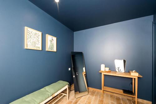 a bedroom with a blue wall and a mirror at 2mn Monaco - Coquet appartement rénové - DM in Roquebrune-Cap-Martin