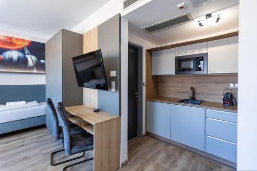 a small kitchen with a desk and a tv in a room at R73 Residences in Pécs