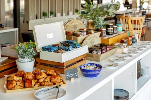 a bakery with pastries and other food items on a counter at Golden Tulip Hotel & Rooftop Martigues Provence in Martigues