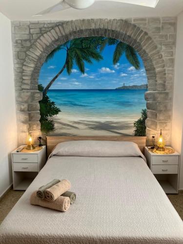 a bedroom with a bed with a view of the ocean at FARO PLAYA in Cullera