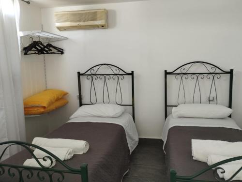 two beds sitting in a room with at Fiore di Loto Rooms in Carini