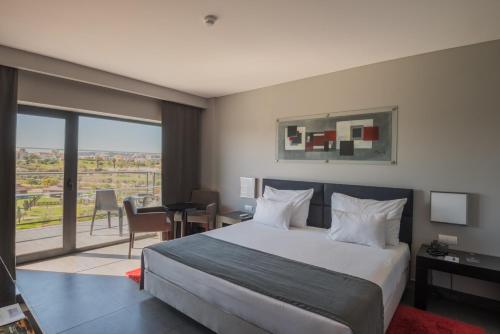 a bedroom with a bed and a room with a view at Vila Gale Lagos in Lagos