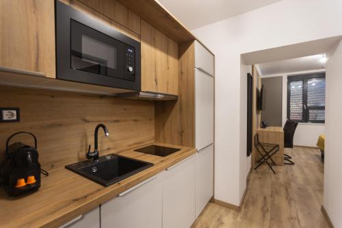 a kitchen with a sink and a microwave at R73 Residences in Pécs