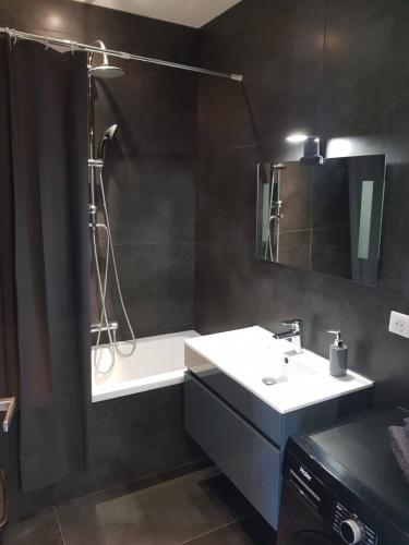 La salle de bains est pourvue d'un lavabo et d'une douche avec rideau de douche. dans l'établissement 3 pièces MOUGINS dans villa contemporaine, à Mougins