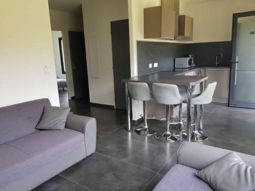 un salon avec un canapé et une table et une cuisine dans l'établissement 3 pièces MOUGINS dans villa contemporaine, à Mougins