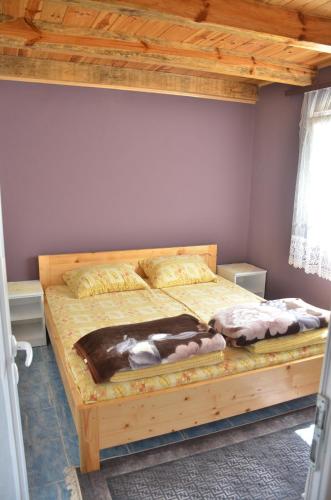 a bedroom with a wooden bed with a wooden ceiling at Negde na Drini 2 in Bajina Bašta
