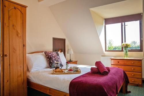 a bedroom with a bed with a tray of food on it at Alpaca Cottage 7mins to Alton Towers in Denstone