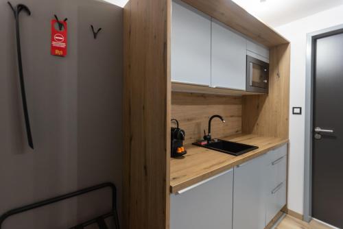 a small kitchen with white cabinets and a sink at R73 Residences in Pécs