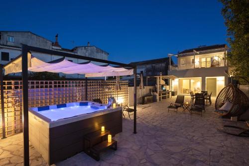 a hot tub on a patio with a building at AGGELLE Villa in Potamós