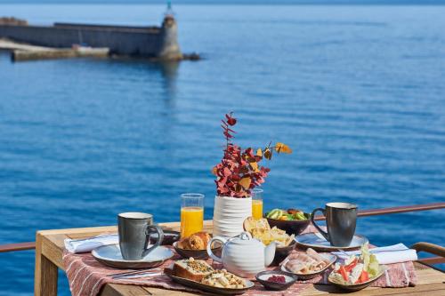 a table with food and a view of the water at Les Roches Brunes in Collioure