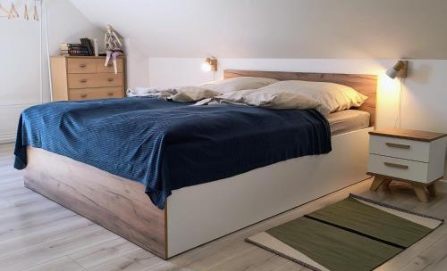a bedroom with a large bed with a blue blanket at Ptasi Zakątek in Tomaryny