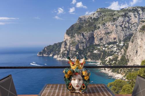 a statue of a woman wearing a headdress overlooking the amalfi coast at Hotel Punta Tragara in Capri