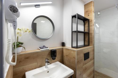a bathroom with a sink and a mirror at R73 Residences in Pécs