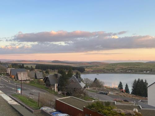 a view of a town with a lake and buildings at Gergovia in Super Besse