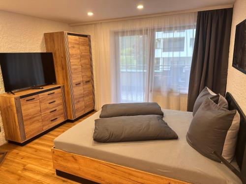 1 dormitorio con 1 cama con TV y vestidor en Weidach Zentrum 2, en Leutasch