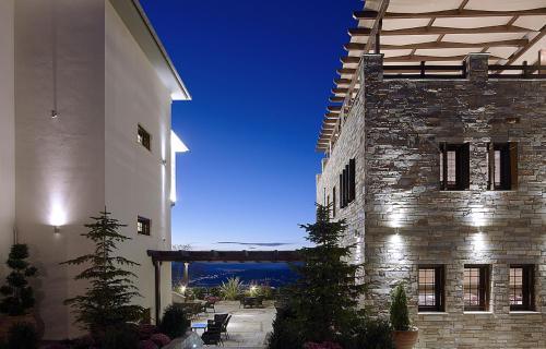 ein großes Steingebäude mit Meerblick in der Unterkunft Stevalia Hotel & Spa in Portaria