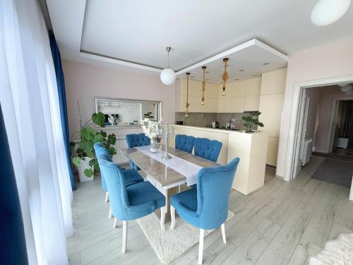 a dining room with a table and blue chairs at Apartmani Avanti Becici in Becici