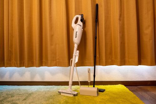 a hair dryer sitting on a yellow rug next to a curtain at BREEZE furano 202 in Furano