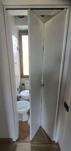 a bathroom with a toilet and a white door at BnBg - Previtali in Bergamo