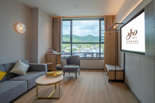 a living room with a couch and a large window at Zhangjiajie Homeinn Plus Hotel in Zhangjiajie