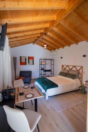 a bedroom with a large bed and a table at Magnolias Cottage in Lousã