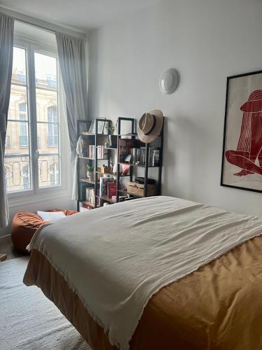une chambre avec un grand lit et une fenêtre dans l'établissement Appartement quartier Montorgueil, à Paris