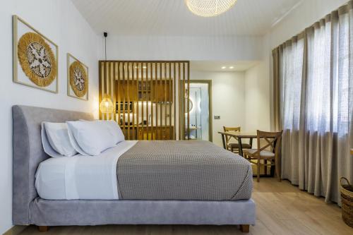 a bedroom with a bed and a dining room at Skopelos Prime Central Stays in Skopelos Town