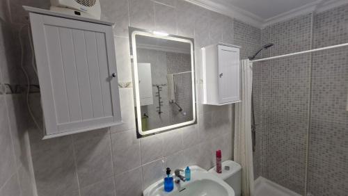 a bathroom with a sink and a mirror and a shower at A 50 metros de la playa in Cádiz
