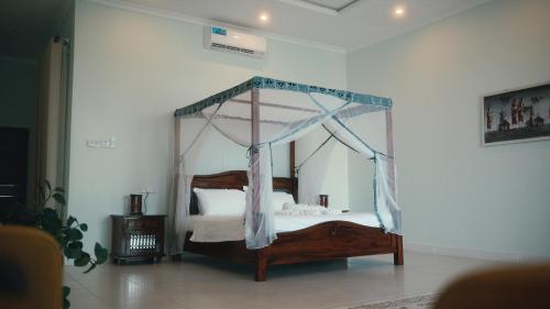 un letto a baldacchino in una stanza di Coral Cliff Villas Zanzibar a Makunduchi