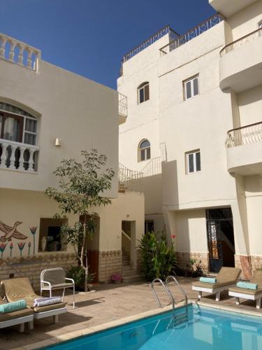 a hotel with a swimming pool in front of a building at Memnon Apartments in Luxor