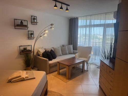 a living room with a couch and a table at STUDIO 46 South Pearl Homes in Sozopol