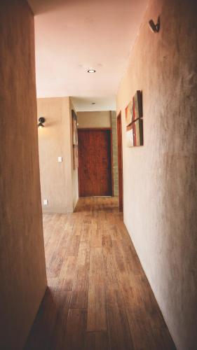 an empty hallway with wood floors and a door at BIMBA en el corazón del bosque, Huasca in La Venta