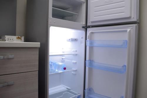 an empty refrigerator with its doors open in a kitchen at La reginella in Carmiano