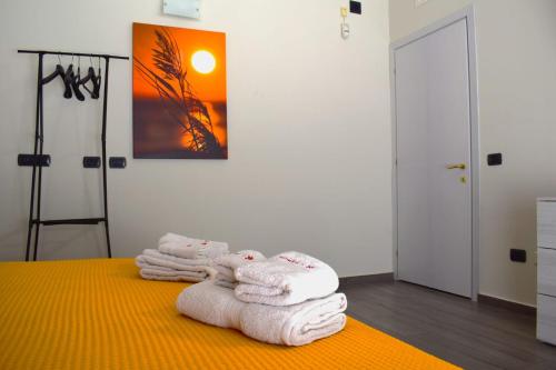 a pile of towels on a bed in a room at La reginella in Carmiano