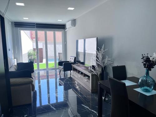 un soggiorno con televisione, tavolo e sedie di IN LOVE a Mahora