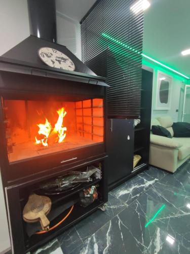 a fireplace with a fire in it in a living room at IN LOVE in Mahora