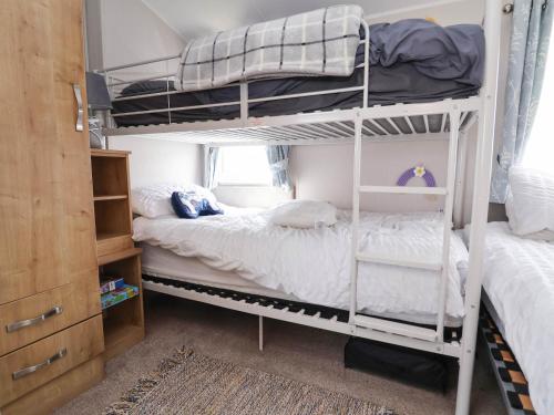 a bedroom with two bunk beds and a closet at Lawi39 in Abergele