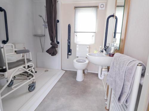 a white bathroom with a toilet and a sink at Lawi39 in Abergele