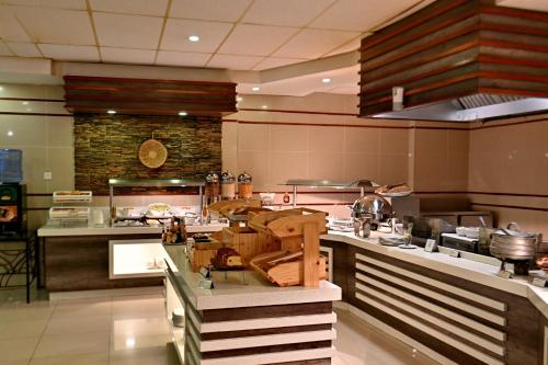 a large kitchen with a counter in a restaurant at Holiday Inn - Bulawayo by IHG in Bulawayo