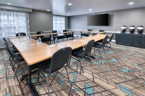a conference room with tables and chairs and a screen at Residence Inn by Marriott Whitby in Whitby