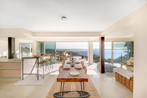a kitchen and living room with a table with dishes on it at La Vigie Mont des oiseaux Vue mer panoramique By HC in Hyères