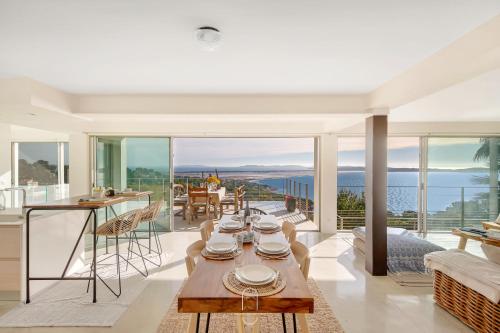 a living room with a table and a view of the ocean at La Vigie Mont des oiseaux Vue mer panoramique By HC in Hyères