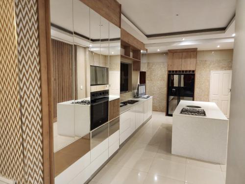 a kitchen with white cabinets and a stove top oven at Eastern Road Executive Suites in Harare
