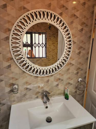 a bathroom with a white sink and a mirror at Eastern Road Executive Suites in Harare